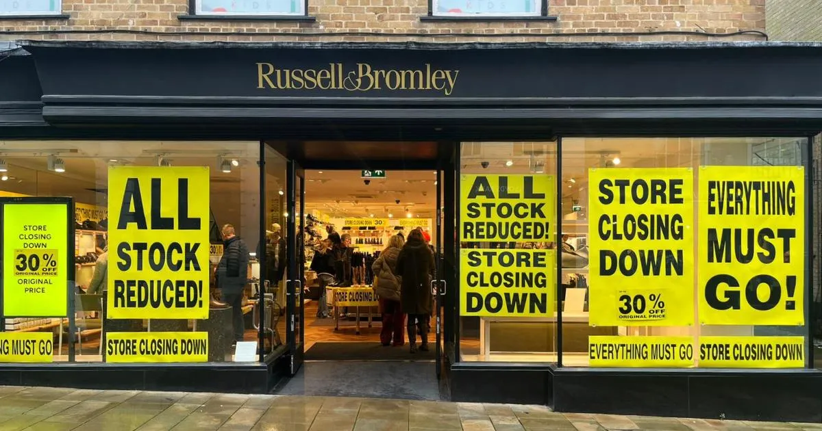 A Russell & Bromley store front covered in closing-down sale posters